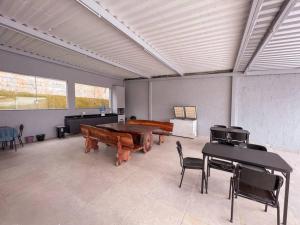 a large room with a piano and tables and chairs at Sítio com Piscina e Hidromassagem Confins in Confins
