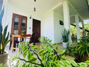 una stanza con tavolo, sedie e piante di Dimuthu Green Villa a Sigiriya