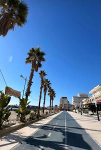 een straat met palmbomen op het strand bij Chrigrey Holiday Apartments & Durres Beach in Durrës