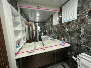 La salle de bains est pourvue d'un lavabo et d'un grand miroir. dans l'établissement Park View 201 double room, à Istanbul