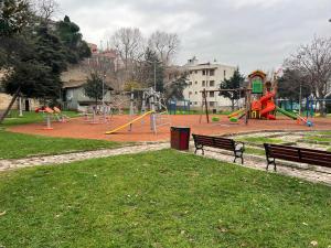 - un parc avec une aire de jeux dotée de bancs et de toboggans dans l'établissement Park View 201 double room, à Istanbul