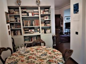 uma sala de jantar com uma mesa e prateleiras de livros com livros em b&bEuropa em Gênova