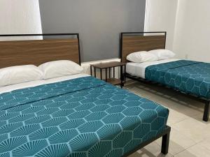 two beds sitting next to each other in a room at Casa Zapopan Hotel in Guadalajara