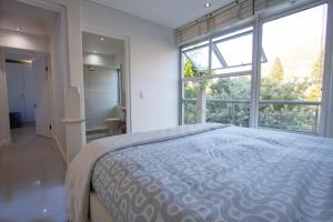 a bedroom with a bed and a tub and a large window at Victoria Views in Cape Town