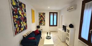 ein Wohnzimmer mit einem Sofa und einem TV in der Unterkunft Andry Apartment with private Garden in Lido di Venezia
