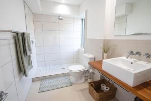 La salle de bains blanche est pourvue d'un lavabo et de toilettes. dans l'établissement Victoria Views, au Cap