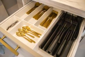 a drawer filled with gold utensils in a kitchen at Fortune Apartments - River view, Contactless in Tartu