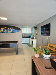 a living room with a table and a kitchen at Surf'O Hostel in Rio de Janeiro