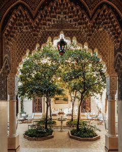 dos árboles en una habitación con mesas y sillas en La Villa des Orangers - Relais & Châteaux en Marrakech