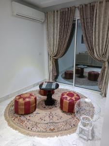 a living room with two ottomans and a table at appartement S+2, proche plage in Monastir