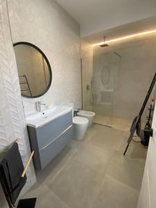 un bagno con lavandino, WC e specchio di Preciosa Casa Centro Histórico Jerez, Parking privado+ WI-FI a Jerez de la Frontera Altre 38 foto
