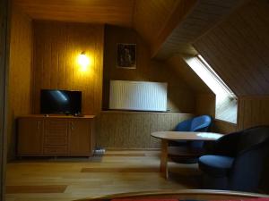 a living room with a television and a table and chairs at GOŚCINIEC AGROZAJAZD in Głuchołazy