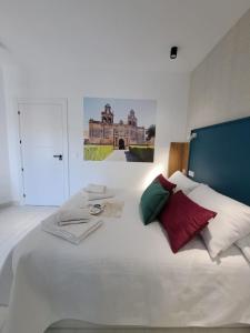 a bedroom with a white bed with red and green pillows at VIVAL RASTRO DELUXE in Úbeda +30 photos