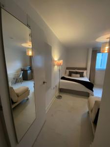 a hotel room with a bed and a mirror at XL Bright Room+Parking+Fridge+Micro - 20min London Bridge - 3 min walk to Train/Bus Station in London