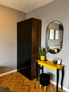 a room with a mirror and a table and a cabinet at Capital Towers "FIRST CLASS" in Rzeszów