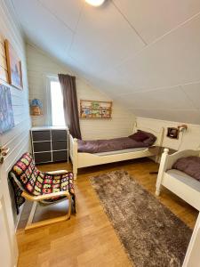 Zimmer mit 2 Betten, einem Stuhl und einem Teppich in der Unterkunft Cozy home in Godfjord in Sortland