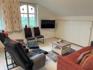 a living room with a couch and chairs and a tv at Deichkrone-Rees in Rees