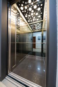 ドプラー・ヴォダにあるHotel Ajlaのガラスのドア、天井、照明が備わるお部屋