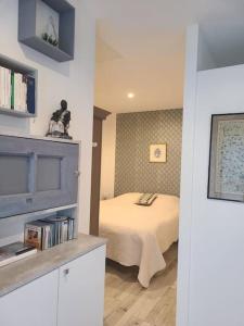 1 dormitorio con cama y estante para libros en Studio/F1 cosy, en Caux