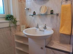 a bathroom with a white sink and a mirror at Springfield Apartment - Train to Glasgow or Edinburgh - Private Parking & Wifi in Airdrie