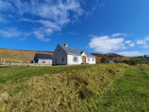a house on a hill with a green field at Glencolmcille Spectacular Views in Glencolumbkille