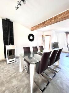 a dining room with a glass table and chairs at La Verrière d'Opale - Maison proche plage et CNPE EDF in Grand-Fort-Philippe