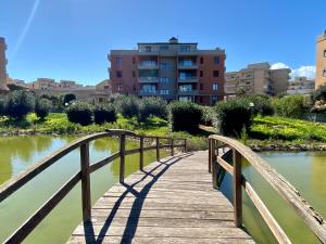 a wooden bridge over a river with buildings in the background at Penthouse Le Isole in Marsala