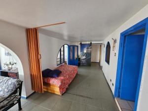 - une chambre avec un lit et une porte bleue dans l'établissement Santorini, à Quintero