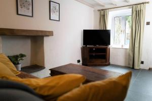 a living room with a couch and a television at Bluebell cottage in Ulverston