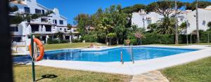 een zwembad in een tuin naast sommige huizen bij ELENA flat A little paradise right on the BEACH in Sitio de Calahonda