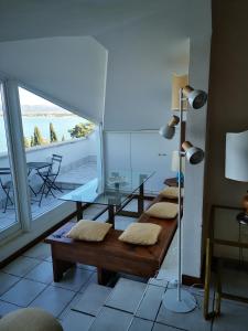ein Wohnzimmer mit einem Tisch und Bänken sowie einem Balkon in der Unterkunft Villa Noi Quattro in Porto Santo Stefano