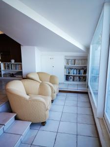 a living room with two couches and bookshelves at Villa Noi Quattro in Porto Santo Stefano
