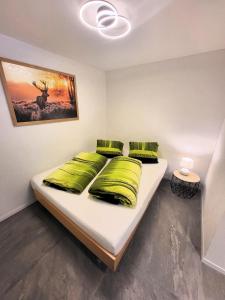 een slaapkamer met een bed met groene kussens bij Chalet Lilo New Studio in Beatenberg