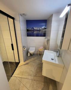a bathroom with a sink and a toilet and a painting at Chalet Lilo New Studio in Beatenberg