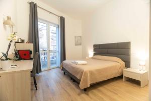 a bedroom with a bed and a desk and a window at Montecristo B&B in Grosseto