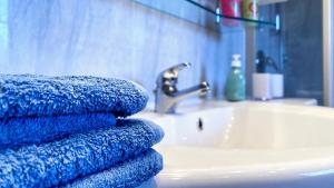 a pile of blue towels sitting on top of a bathroom sink at Elegante Ferienwohnung Relax in Prien am Chiemsee +21 photos