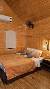 a bedroom with a large bed in a wooden wall at Phoenix Hotel Pool Villa in Hoi An
