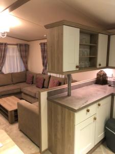 a kitchen and a living room with a couch at Fairways 2 Turnberry Holiday Park in Turnberry