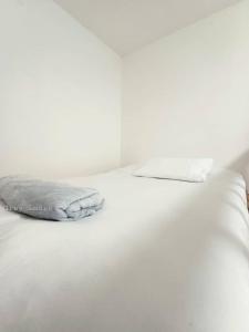 a white bed with white sheets and pillows on it at Sann's Lodge in Putrajaya