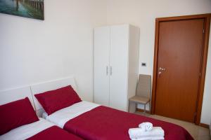 1 dormitorio con 2 camas con sábanas rojas y blancas en BB CA VENEZIA en Marghera
