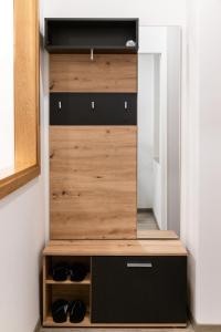 a closet with wooden doors and shoes in it at Oliver street apartment Vipava - 50m from city center in Vipava