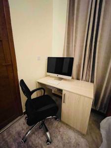 a desk with a computer and a chair in a room at 1 Bed Cozy Apartment Free Wi-Fi Netflix Hot Shower in Dar es Salaam