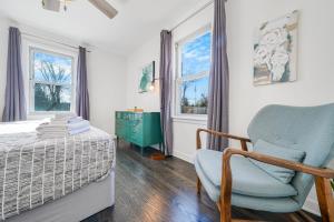1 dormitorio con 1 cama, 1 silla y ventanas en NEW Urban Comfort On Grant St en Lake Geneva
