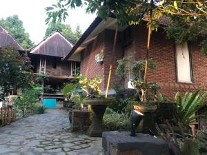 une maison en briques avec une passerelle en pierre devant elle dans l'établissement Kraras Munduk Guest House & DonBiyu Rendezvous Restaurant, à Munduk