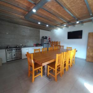 uma grande cozinha com uma mesa de madeira e cadeiras em Lo de Lidia em Olavarría