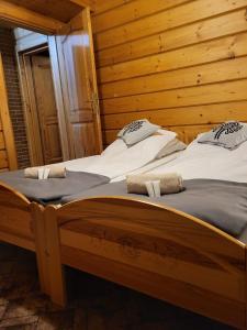 Duas camas individuais num quarto de madeira em Apartament Harenda em Zakopane
