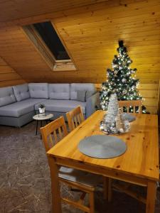 uma sala de estar com uma árvore de Natal e uma mesa de madeira em Apartament Harenda em Zakopane