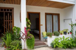 ein Haus mit einer hölzernen Veranda mit Pflanzen in der Unterkunft Akiri Dhigurah in Dhigurah