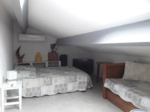 Schlafzimmer im Dachgeschoss mit 2 Betten und einem Sofa in der Unterkunft La maison des enfants in Mèze