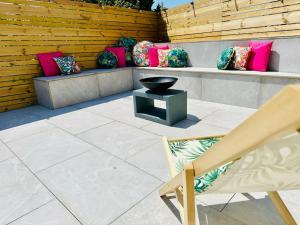 a patio with pillows and a black bowl on a bench at Social Central - No 1 for large groups in Cardiff